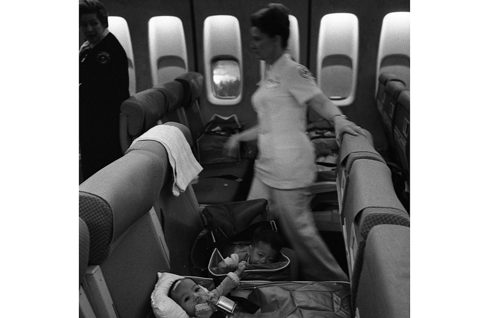 Krankenschwestern und vietnamesische Flüchtlingskinder auf einem Operation Babylift-Flug nach seiner Ankunft am San Fransisco International Airport 1975_World History ArchiveAlamy